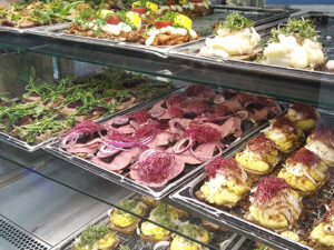 Brugeradfærd og fødevarer. Kantinen skal anvend nudging for at få en god brugeroplevelse. Brugeradfærden afhænger af hvordan du indretter kantinen. På billedet ses smørrebrød som betjenes af personalet.